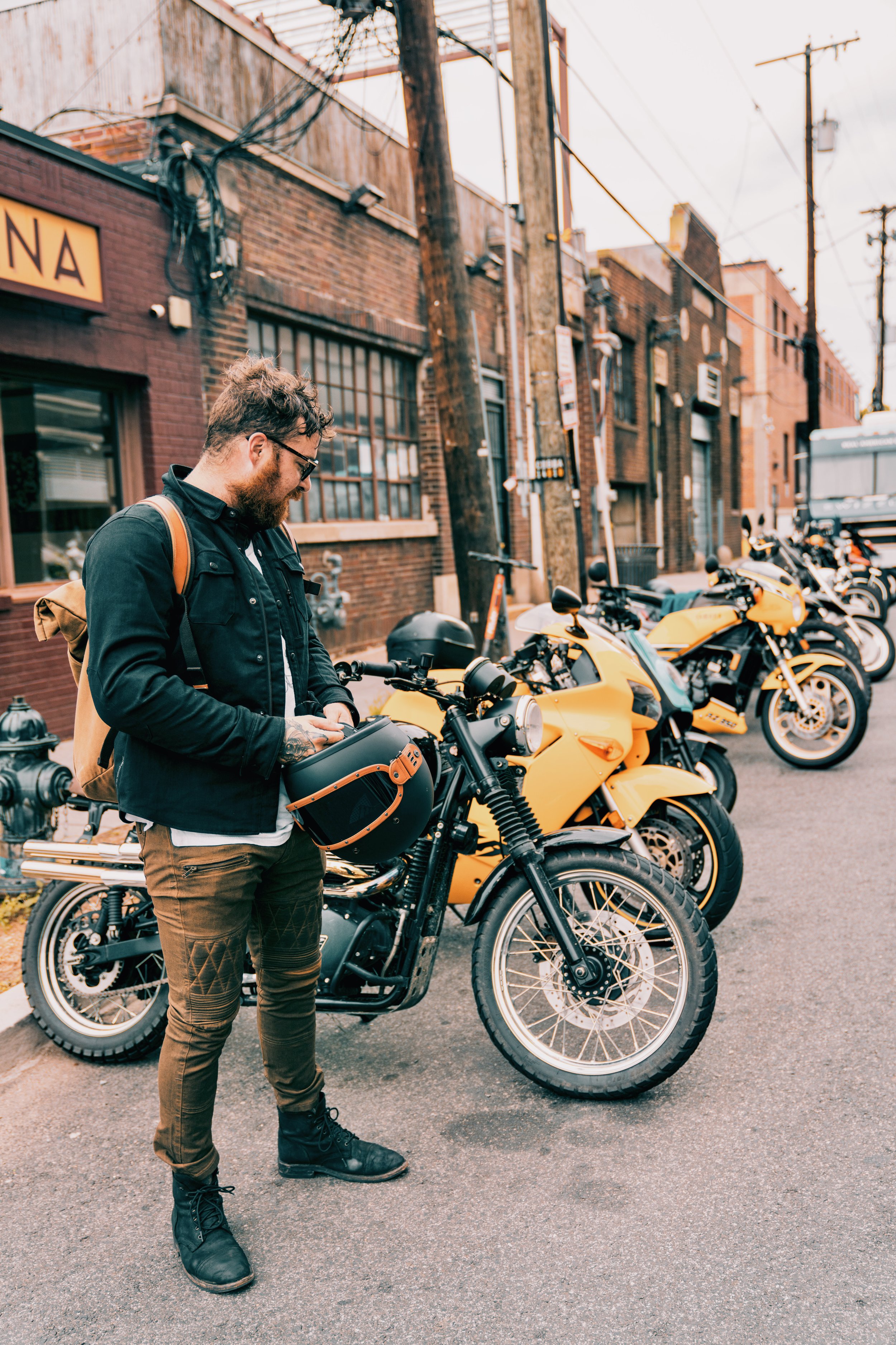 Austin removing his gear after a motorcycle ride to a meetup